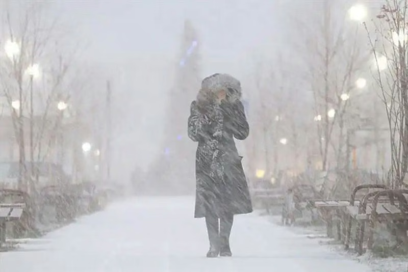 Una persona, abrigada, caminando en la nieve