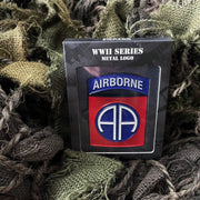 Insignia metálica de la 82nd Airborne Division sobre fondo blanco