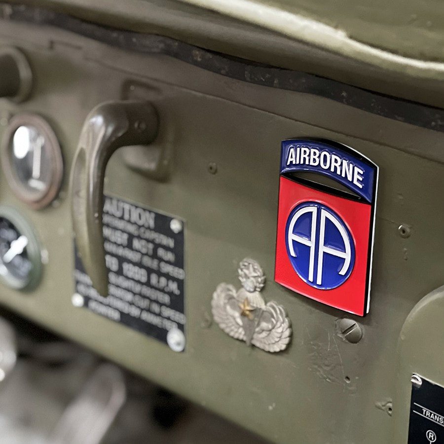Insignia metálica de la 82nd Airborne Division sobre fondo blanco