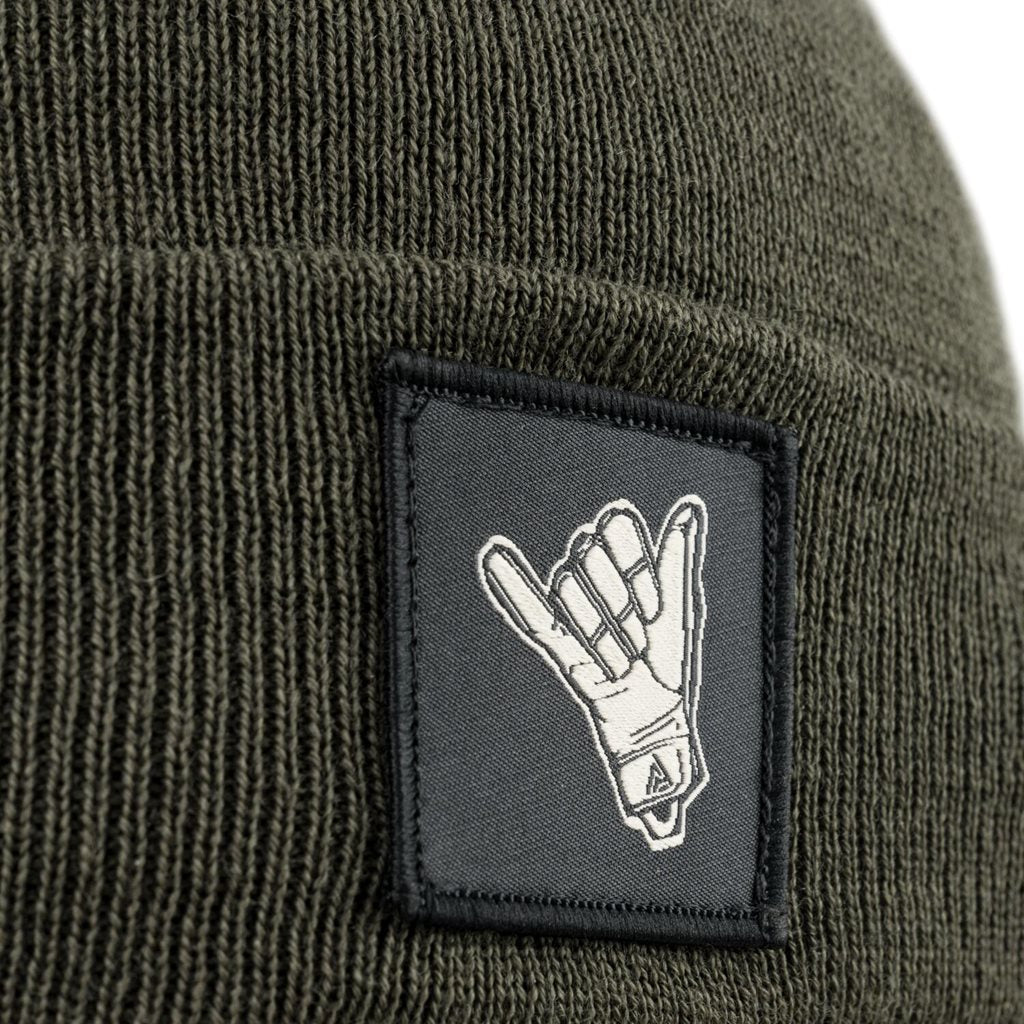 Gorro SHAKA Merino negro con pequeño parche que muestra el gesto SHAKA