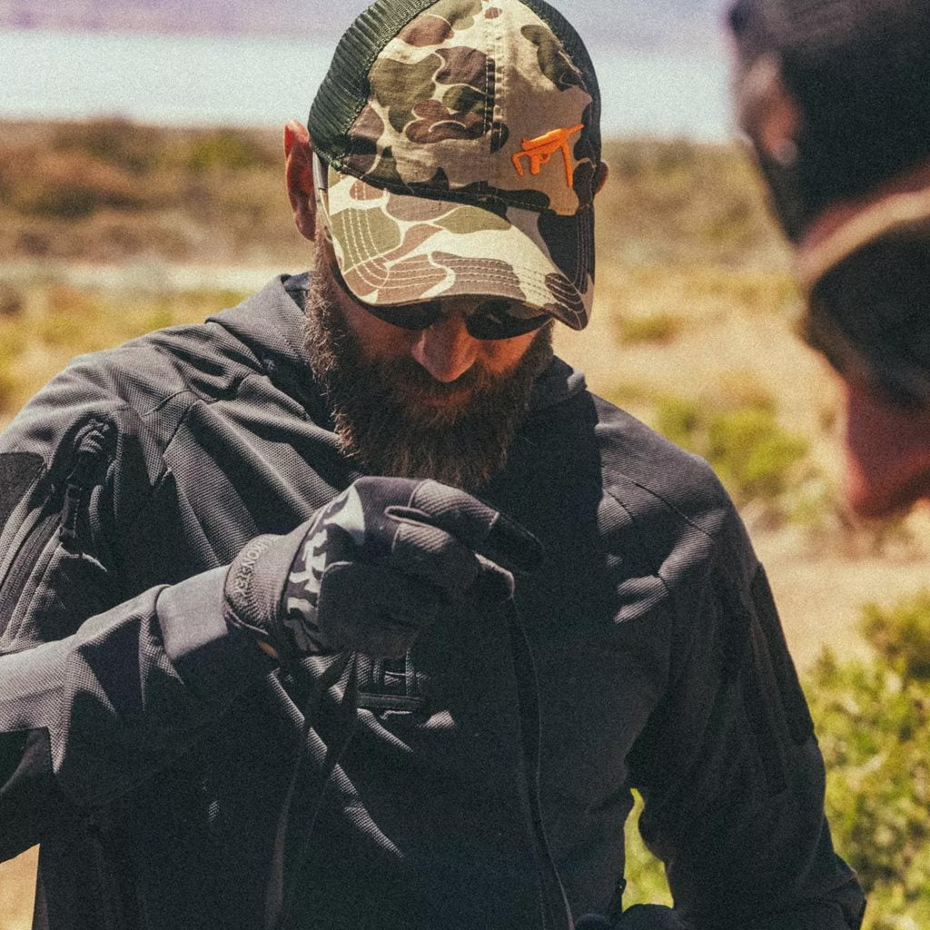 Gorra trucker GREASE GUN en estampado Duck Hunter con bordado del arma M3A1