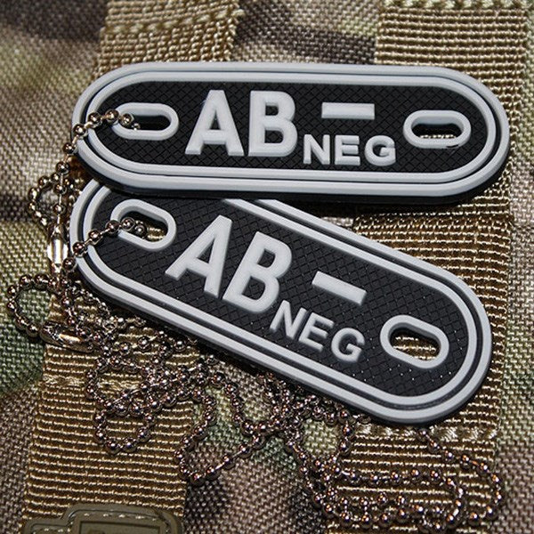 Placas identificativas negras de plástico marcadas AB- (negativo), dos chapas en una cadena