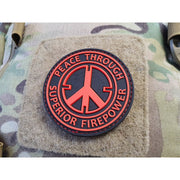 Parche PVC negro y rojo con texto 'Peace Through Superior Firepower', 6,5 cm, respaldo con velcro