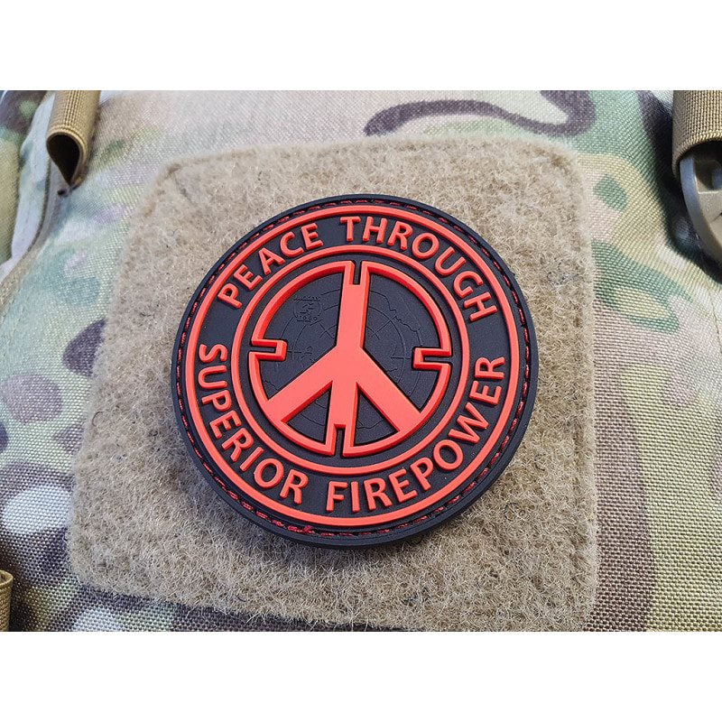 Parche PVC negro y rojo con texto 'Peace Through Superior Firepower', 6,5 cm, respaldo con velcro