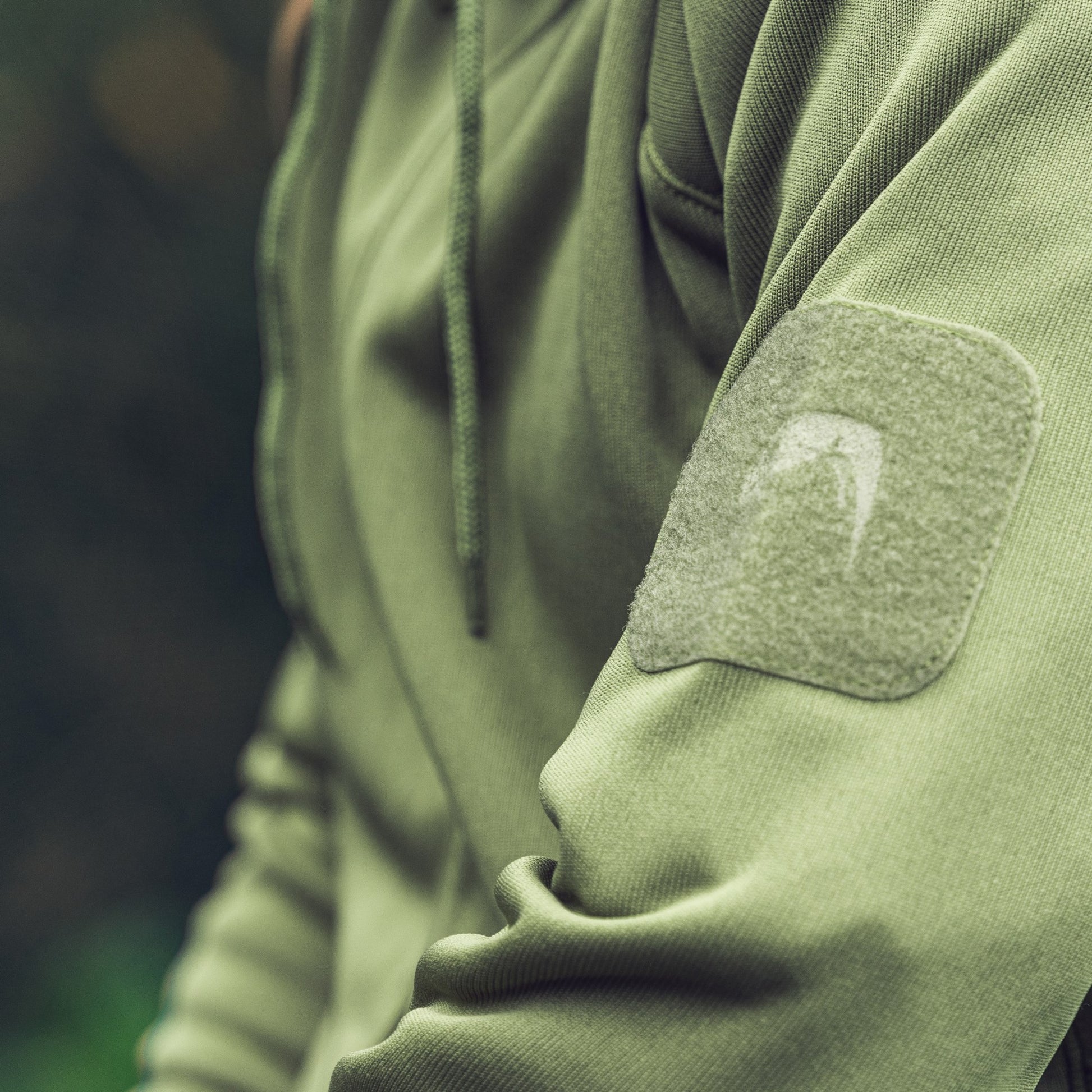 Sudadera STORM fleece verde con capucha ajustable, bolsillos y paneles VELCRO